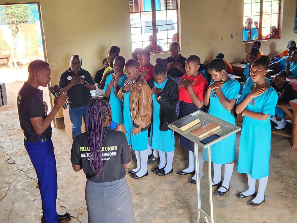 Students praying during a Bible Union mentorship session